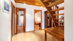 Un escalier en bois, une table en bois et un couloir avec un plancher et des portes en bois.