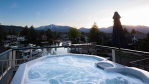 Un jacuzzi con vistas a montañas y un lago.