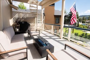 A balcony with a sofa, chairs, a grill, a fire pit, and an American flag. - Basecamp Luxury Tahoe Keys waterfront retreat (South Lake Tahoe)