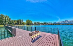 A wooden pier with a bench, overlooking a lake with mountains in the background. - Basecamp Luxury Tahoe Keys waterfront retreat (South Lake Tahoe)