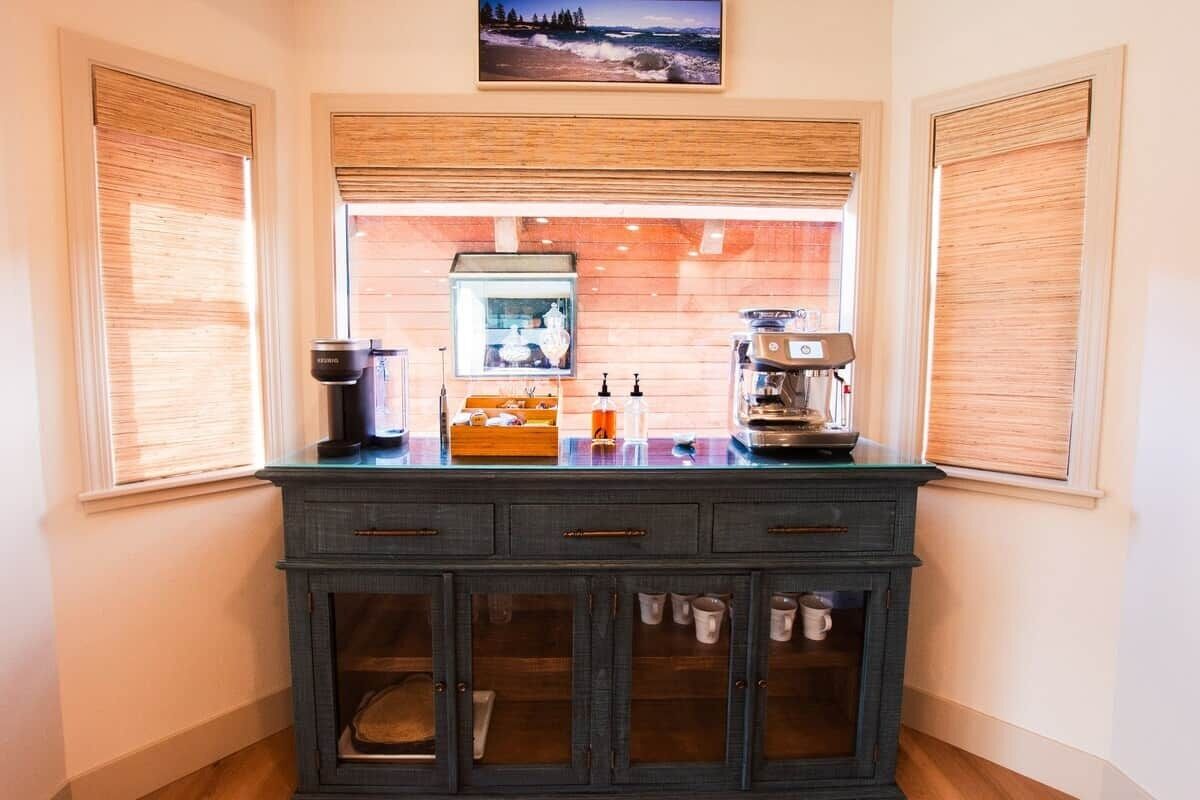 Una cucina con isola in vetro, mobili in legno e una finestra con persiane.