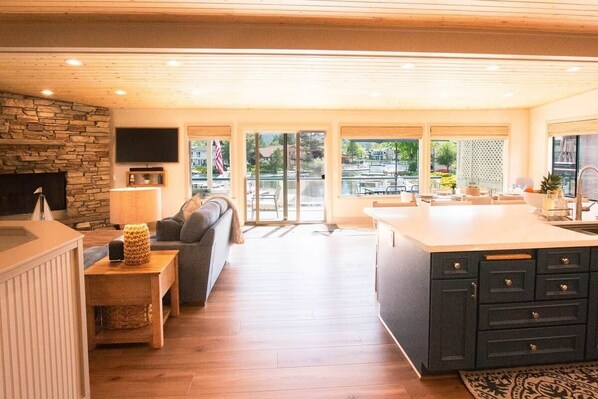 A modern kitchen with a stone accent wall, a built-in TV, and a large island.