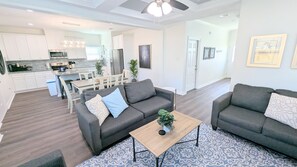 Ein modernes Wohnzimmer mit zwei grauen Sofas, einem Couchtisch und einem gemusterten Teppich.