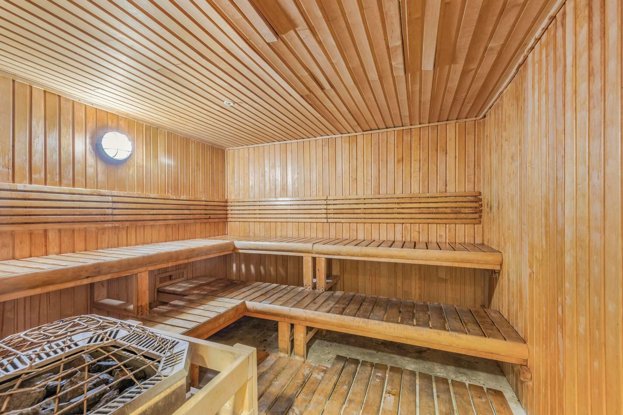 A sauna with wooden benches and a stone heating system.