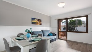 Uma sala de jantar moderna com mesa, cadeiras e um sofá.