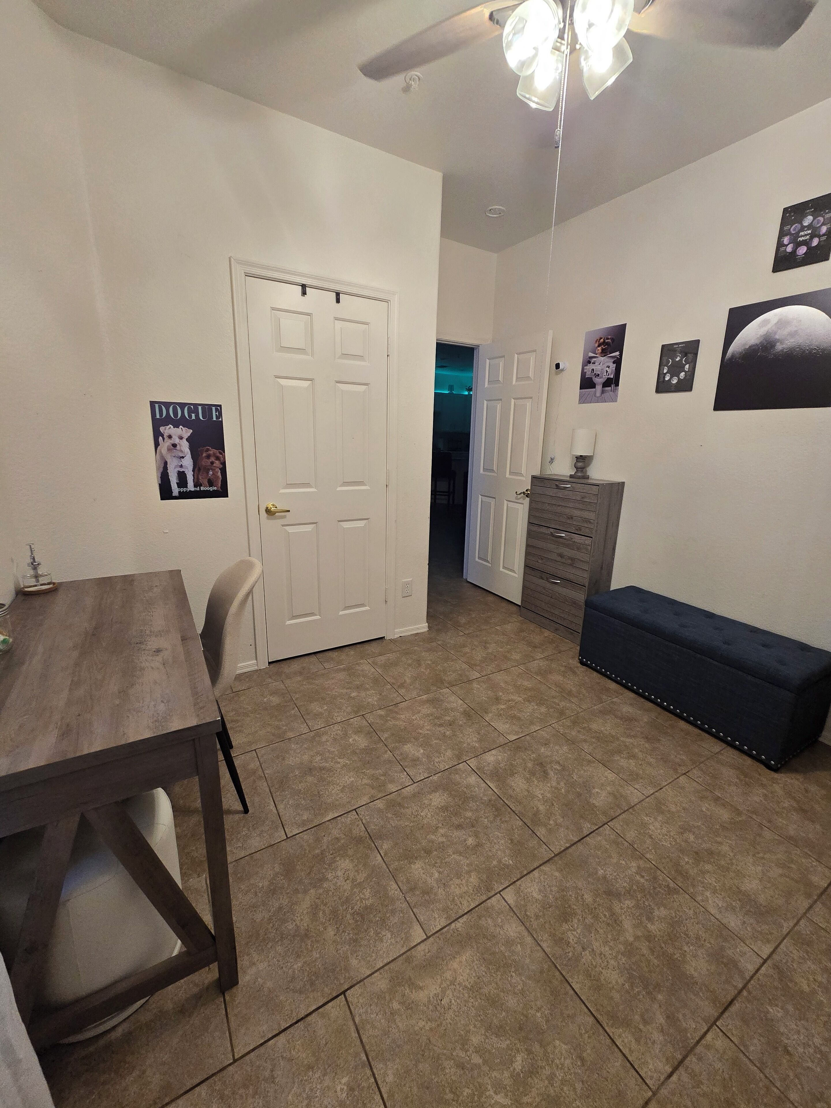 A dining area with a wooden table and chairs, a bench, and a ceiling fan.