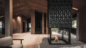 Un intérieur moderne avec des planchers en bois, une cheminée en verre et un coin salon.