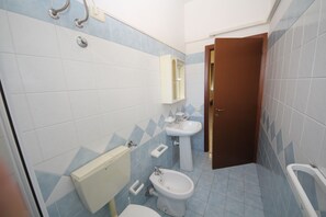 Ein Badezimmer mit Toilette, Bidet und Waschbecken.