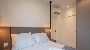Una camera d'albergo con un letto, un comodino e un armadio.