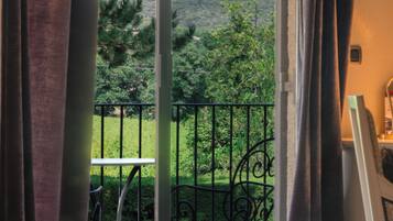 Chambre Deluxe, balcon, vue jardin | Coffres-forts dans les chambres, bureau, fer et planche à repasser