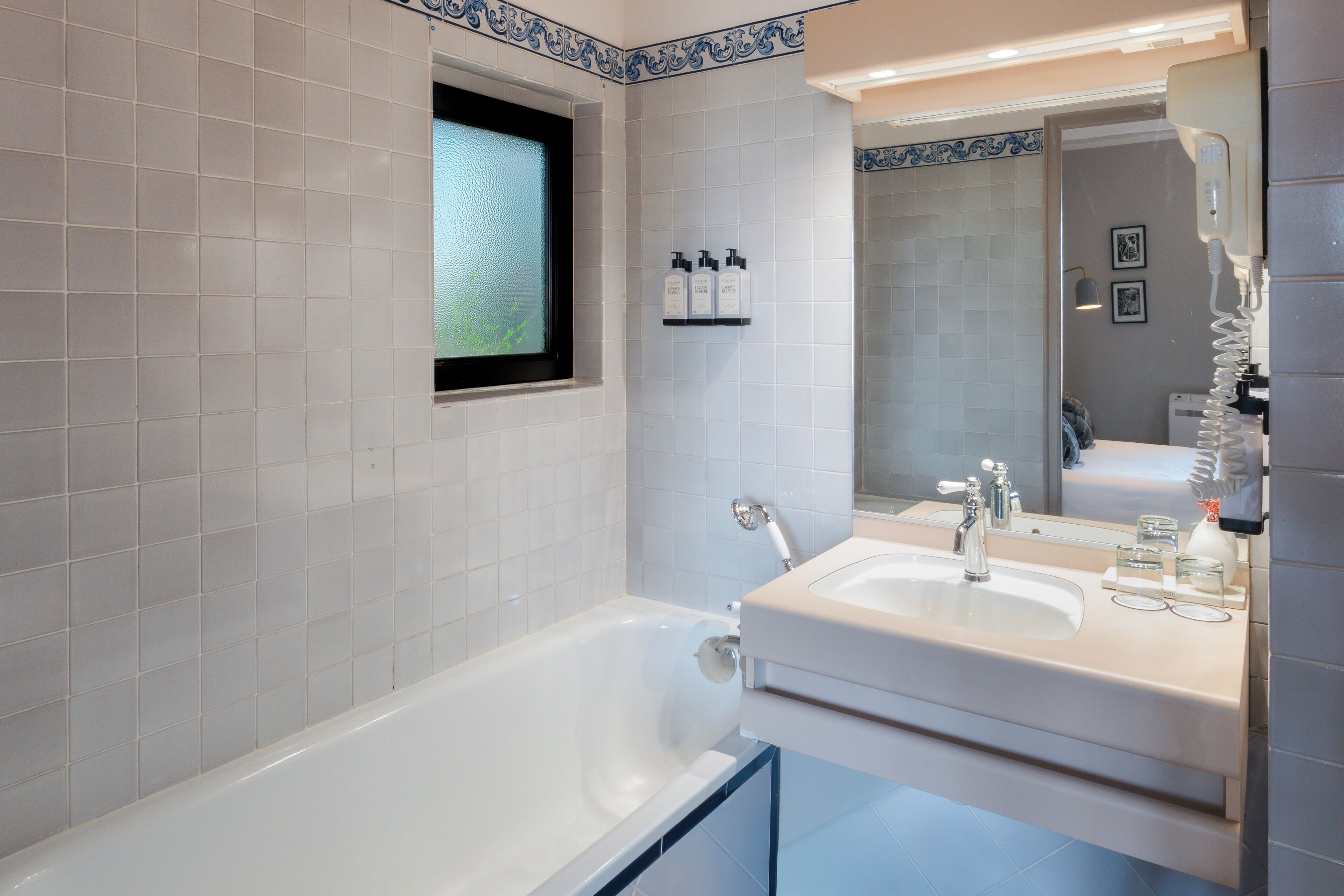 A modern bathroom with a bathtub, a sink, and a window.