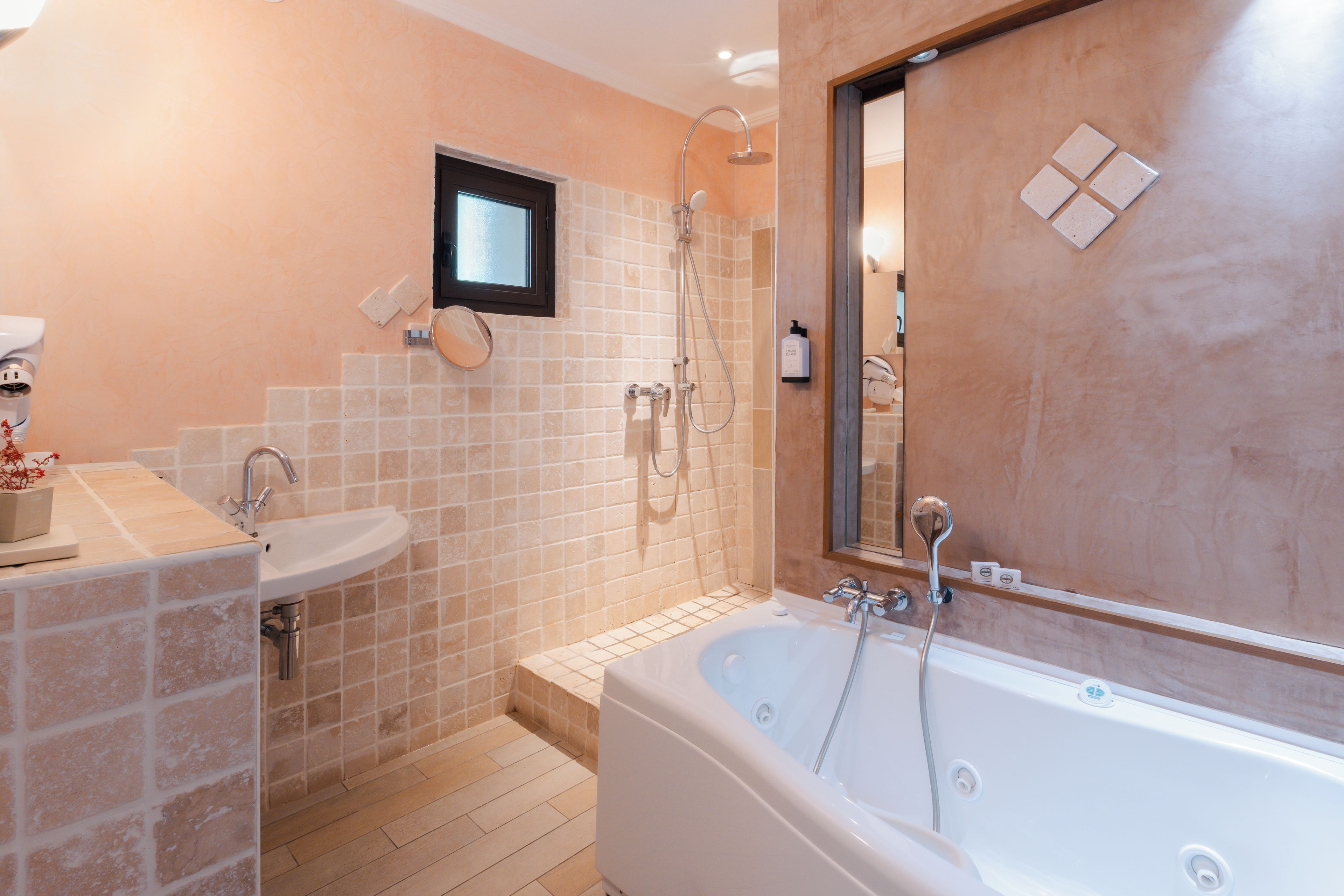 A bathroom with a bathtub, a sink, and a shower area.