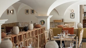An interior with a dining area featuring wooden furniture, a white arched ceiling, and various decorative items. - Le Mas de Guilles (Lourmarin)