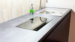 A kitchen with a stainless steel sink, a soap dispenser, and a wooden countertop. - The Apartment Agrigento (Agrigento)