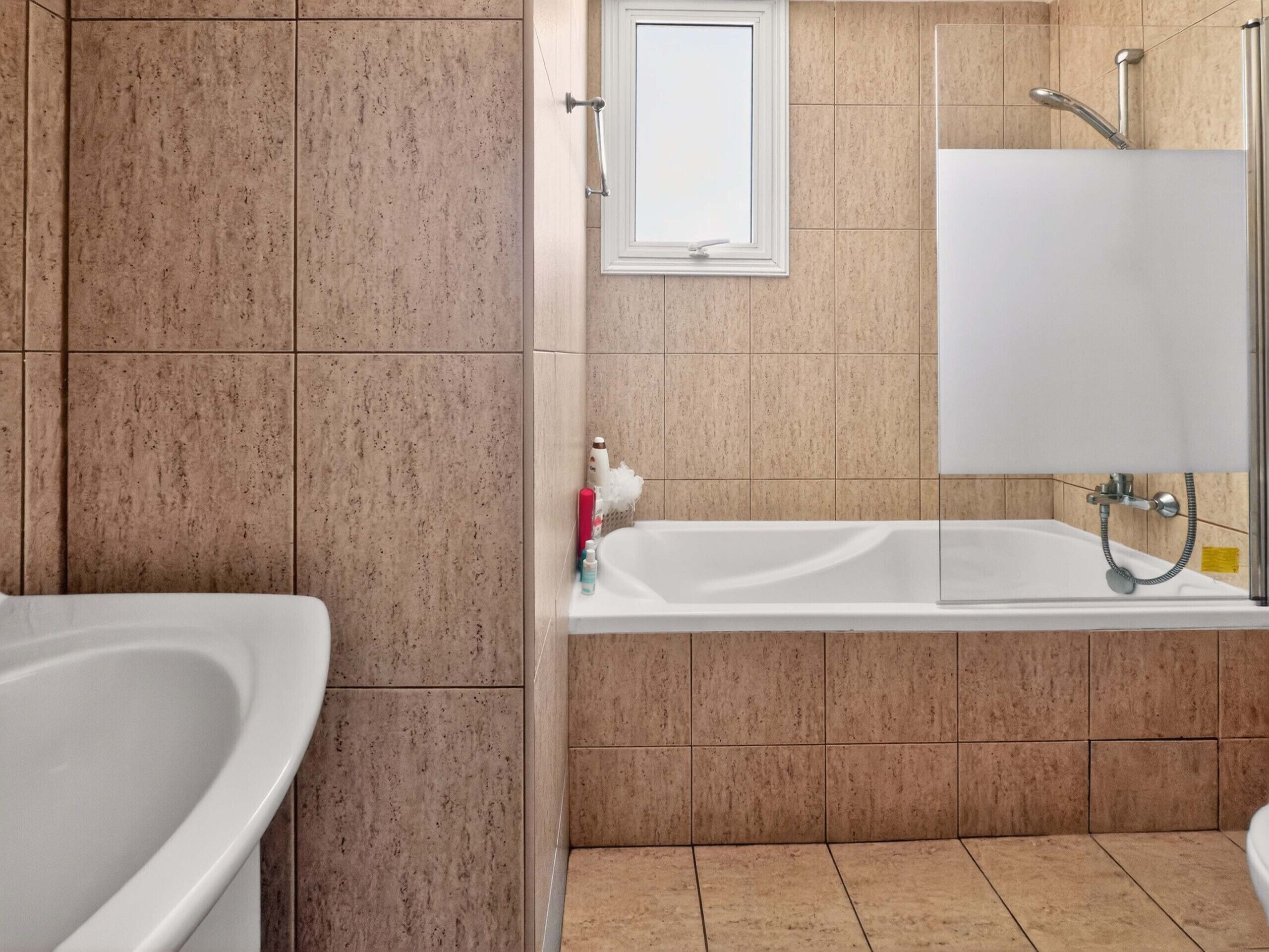 Un baño con bañera, ducha y lavamanos.