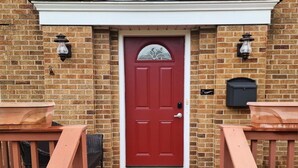 A red door with a white trim and a triangular pediment above it. There are two wall-mounted light fixtures on either side of the door. - 513Company - Theater +Location (Cincinnati)