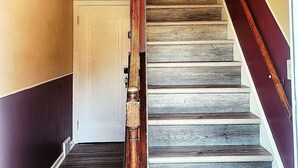 A staircase with wooden steps and a wooden handrail, leading to a white door. - 513Company - Theater +Location (Cincinnati)