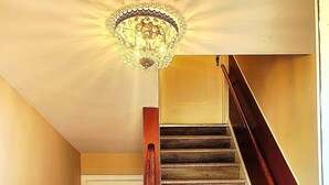 Eine Treppe mit Holzboden und Holzhandlauf, die zu einer weißen Tür führt.