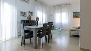 A dining area with a table and chairs, a sofa, a coffee table, and a painting on the wall. - GuestHost - Large 160 sqm apartment, ideal for groups or families up to 6, located on the first floor of a building with an elevator (NOT for guests with disabilities).The property is located in a quiet area, yet fully served by all main amenities and we (Palermo)