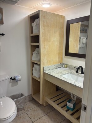 A bathroom with a wooden vanity, a sink, a mirror, and a toilet. - Oceanfront Paradise with Amazing Views (Myrtle Beach)