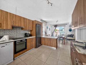 A modern kitchen with wooden cabinets, a stainless steel refrigerator, and a coffee machine. - Villa Rena: Sleeps 8 ~ Mins to Beach ~ Private Pool (Protaras)