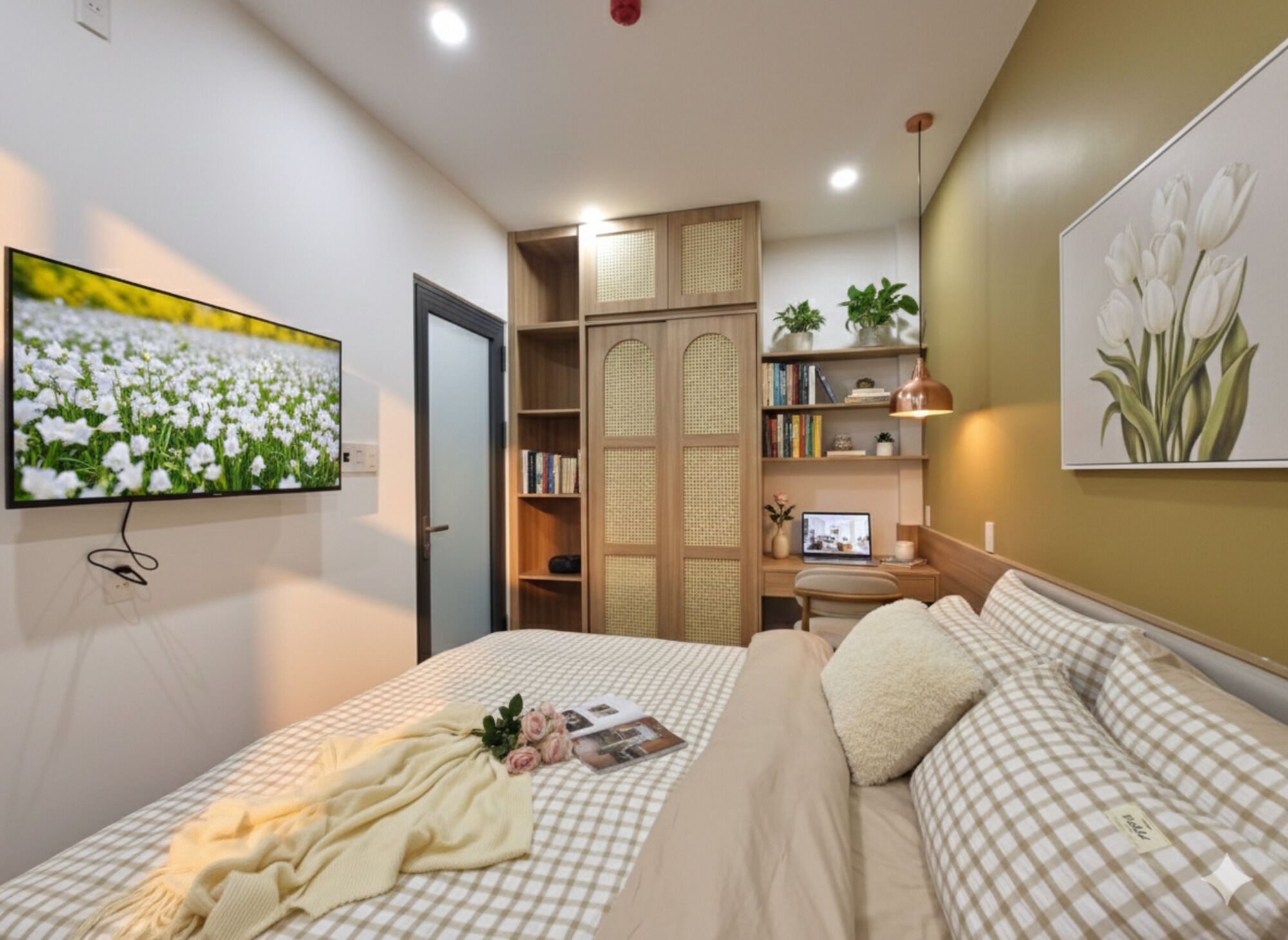 A bedroom with a bed, a desk, a bookshelf, and a television.