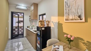Eine kleine Küche mit Kühlschrank, Spüle und Holzschränken.