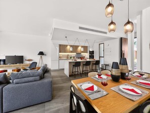 A modern living space with a dining area, kitchen, and seating. - Azure Amber Villa / Private Pool / Sea View (Protaras)