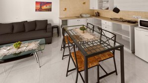 A modern apartment with a dining area, kitchen, and living room. - Napa Central Apartment (Ayia Napa)
