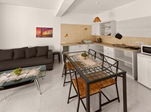 A modern apartment with a dining area, kitchen, and living room. - Napa Central Apartment (Ayia Napa)