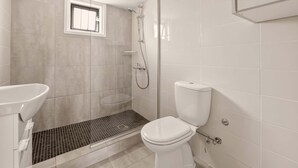 A bathroom with a shower, toilet, and sink. - Napa Central Apartment (Ayia Napa)