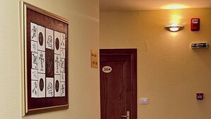 Ein Flur mit einer Tür mit der Aufschrift 304, einem gerahmten Kunstwerk an der Wand und einem Lichtschalter.