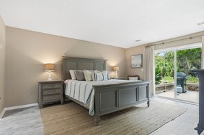 Une chambre à coucher avec un lit, des tables de chevet et une vue sur l’extérieur.