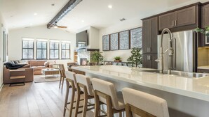 A modern kitchen with a large island, bar stools, and a built-in oven. - New! Snowcreek Luxury Retreat w Mountain Views 641 (Mammoth Lakes)