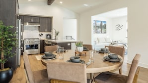 A modern kitchen with dark wood cabinets, stainless steel appliances, and a central island. - New! Snowcreek Luxury Retreat w Mountain Views 641 (Mammoth Lakes)