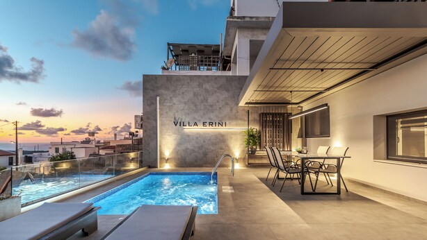 Un área de piscina en la azotea con sillones de descanso, una mesa de comedor y un letrero que dice "Villa Erini".
