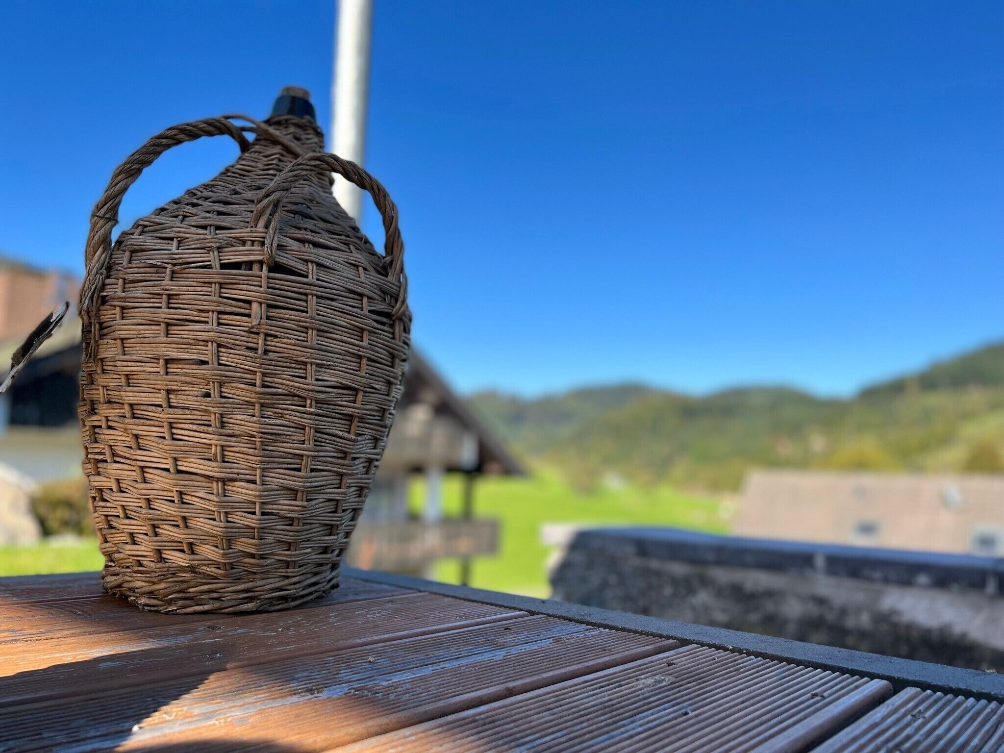 A wicker basket with handles on a wooden surface.