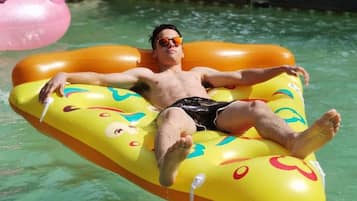 Alberca al aire libre, sombrillas en la alberca y camastros