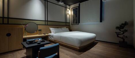 Una moderna camera d'hotel con un letto, una scrivania, una sedia, uno specchio, una pianta in vaso e un condizionatore d'aria a parete.