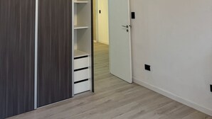 Ein Flur mit einem Holzschrank, einer weißen Tür und einer Deckenleuchte.