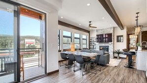A spacious living area with a dining table, sofas, and a fireplace. - AC in Downtown 2/2 with Mountain Views and easy access! (Winter Park)