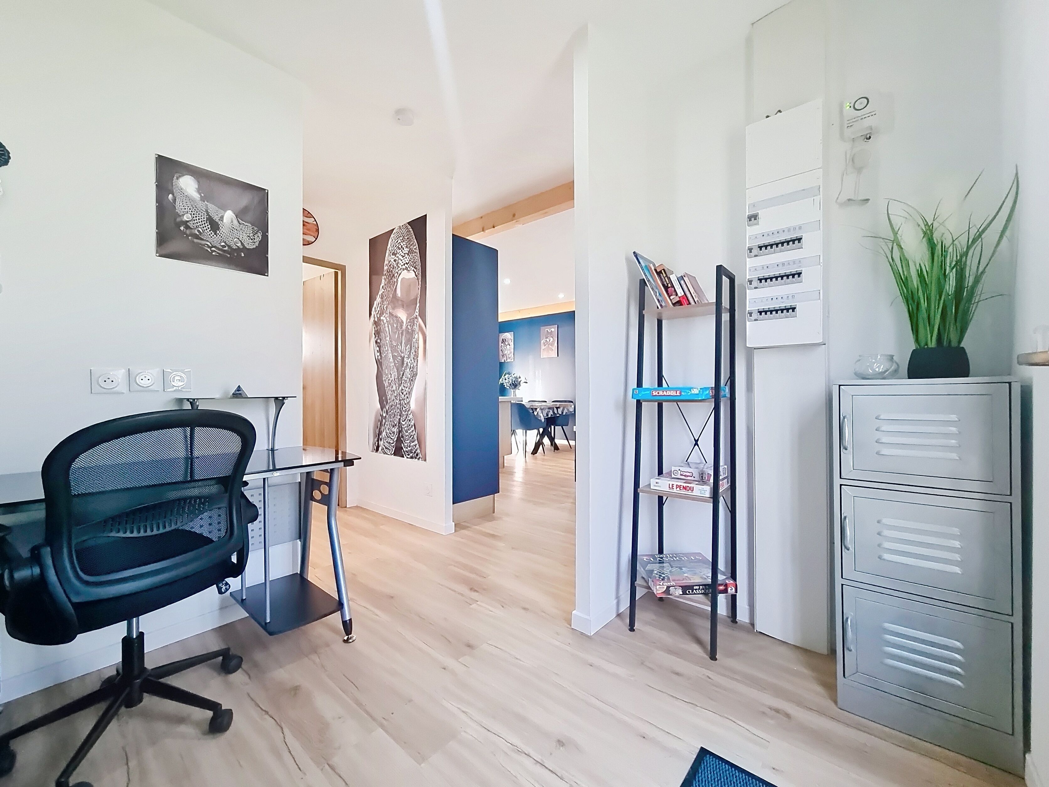 Un espacio de oficina moderno con escritorio, silla, estantería y archivadores.