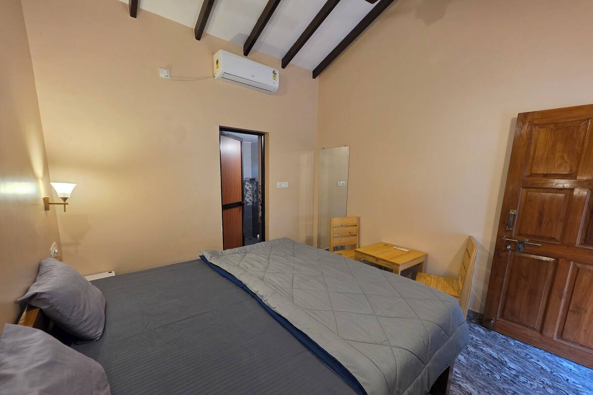 Une chambre à coucher avec un lit, une table de chevet en bois, un miroir et une armoire.