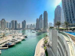 A marina with boats docked, a waterfront promenade, and high-rise buildings in the background. - FIRST CLASS | 1BR | Marina View | Sea & Ain Dubai (Marina)
