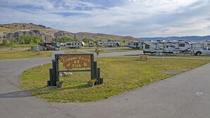 Schild für den Copper Court RV Park, im Hintergrund parkgeordnete Wohnmobile.