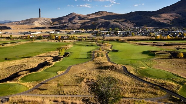 Ein Golfplatz mit freiem Blick auf die umliegende Stadt und Berge.