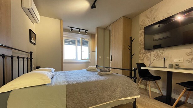 A bedroom with a bed, a desk, and a TV. - Piazza Delux Downtown Cozy Studio (Tirana)