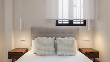 Een slaapkamer met een bed, twee nachtkastjes, een raam met zonwering en een wandlamp.
