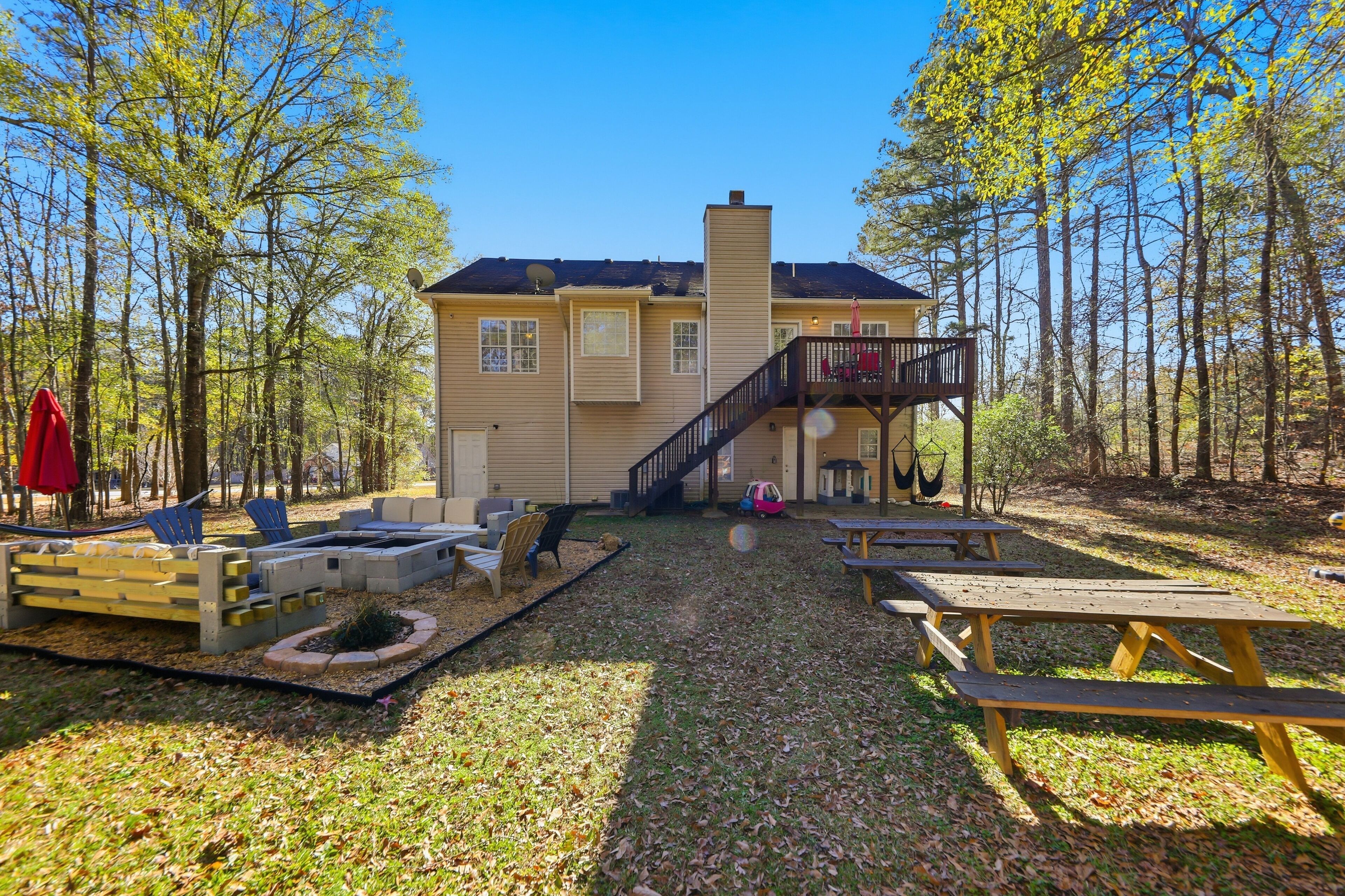 A lodge with a deck, picnic tables, and a fire pit area.