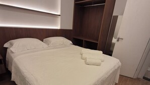 Un dormitorio con una cama grande, un armario y una puerta.